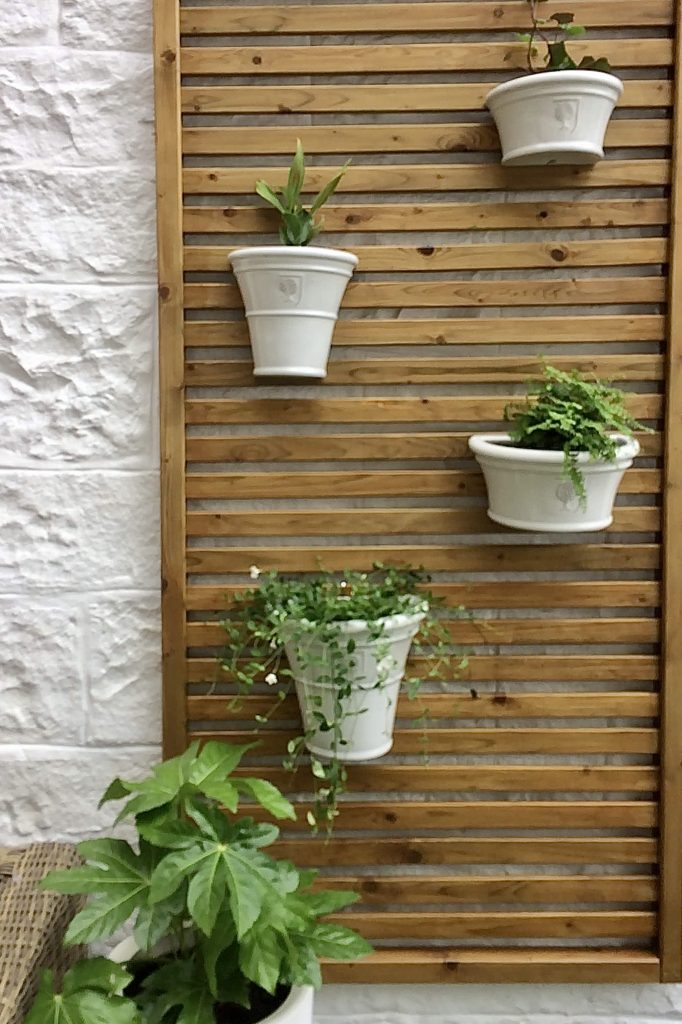 Vertical gardening with hanging white planters.