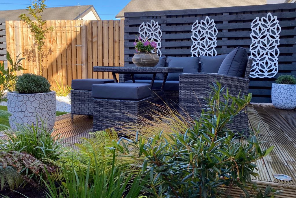 A cosey outdoor seating area with privacy screens designed for a contemporary Edinburgh garden.