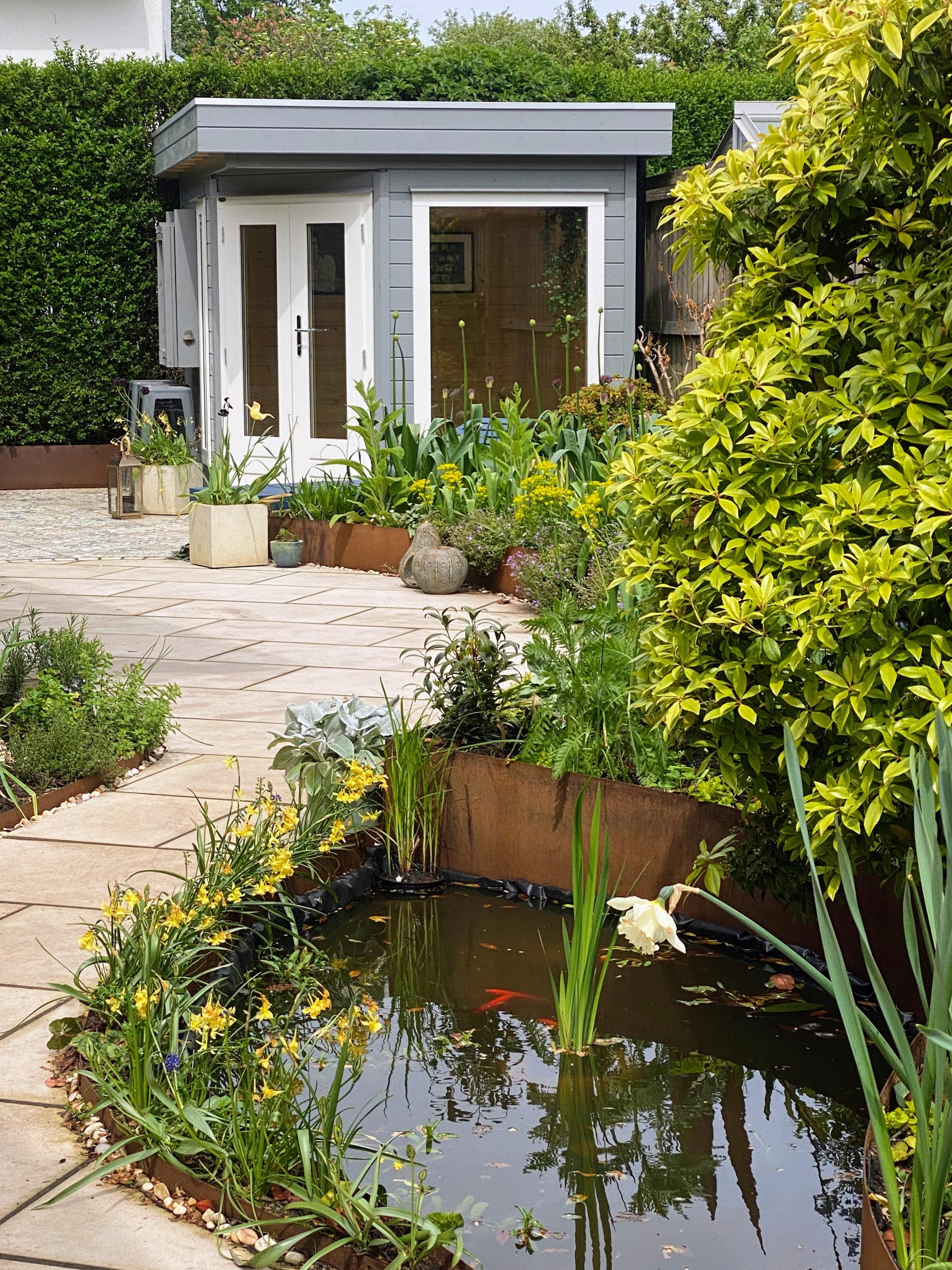 dinburgh patio garden transformation with Corten steel planters, paving tiles, and a pond.