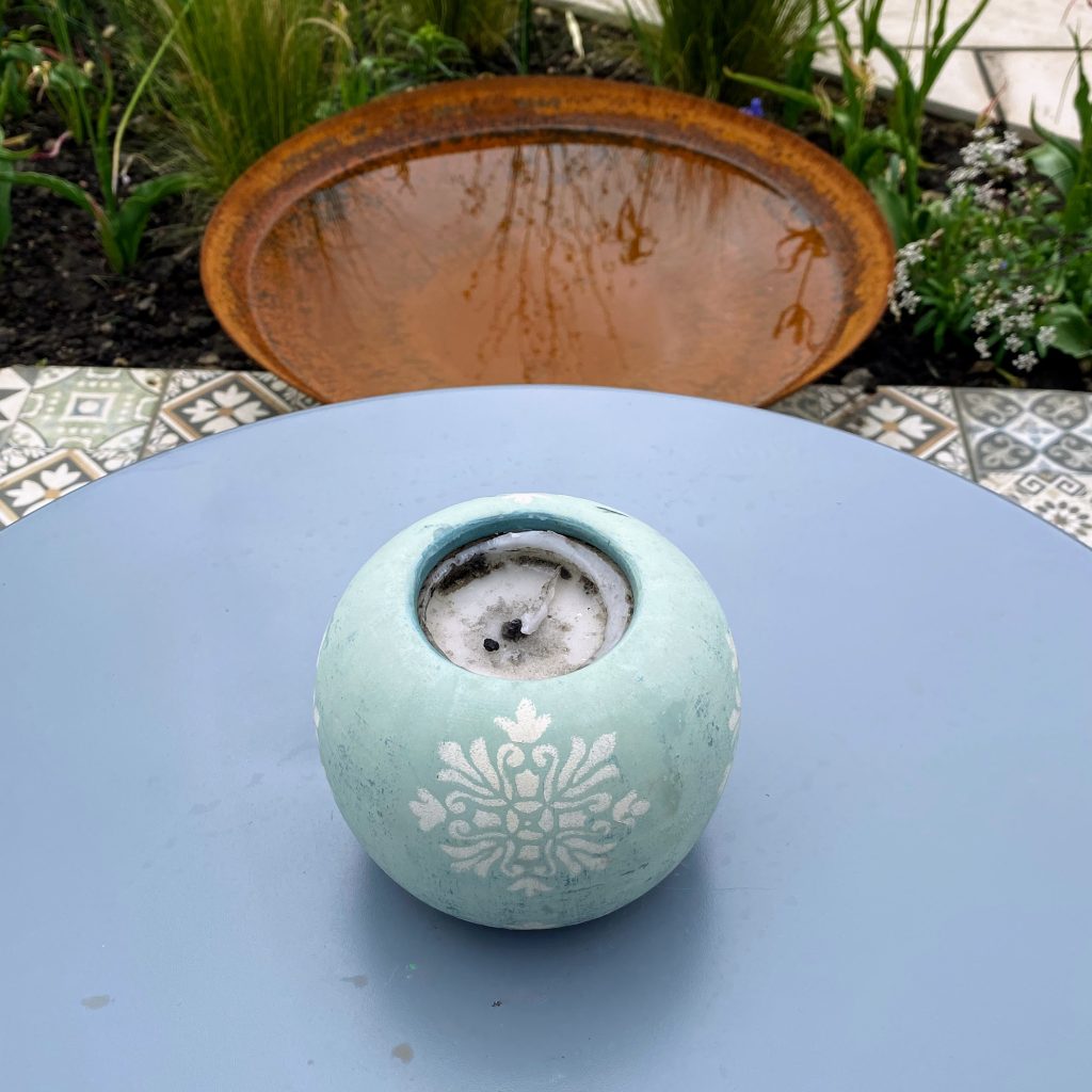 Stylish blue candleholder for outdoor table decor.