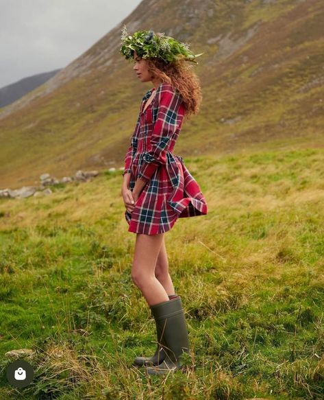 Model in a red tartan dress wearing a floral wreath standing in the Scottish Highlands. Styled by Angela Moffat, Stylist, Edinburgh, Scotland