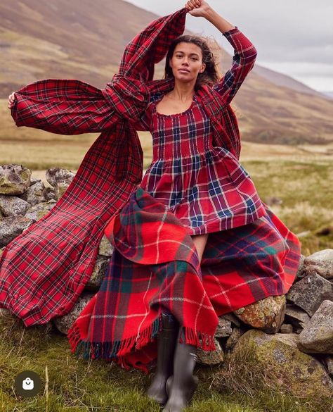 Model in a red tartan dress draped in vibrant tartan fabric in the Scottish Highlands. Styled by Angela Moffat, Stylist, Edinburgh, Scotland.