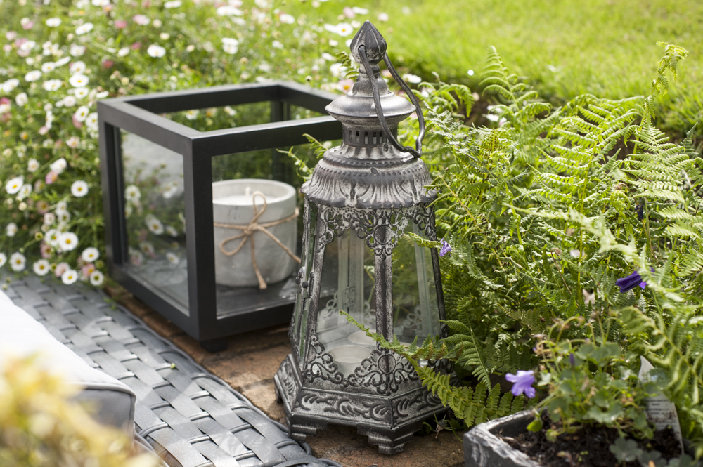 Antique lanterns add elegance to lush garden settings.